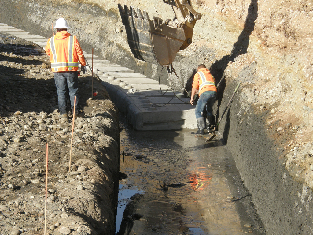 Two workers setting blocks for retaining wall