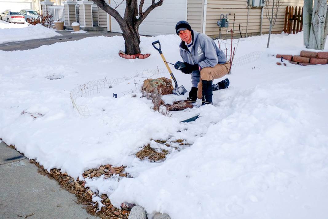 Meter reader with shovel and snow covered pit