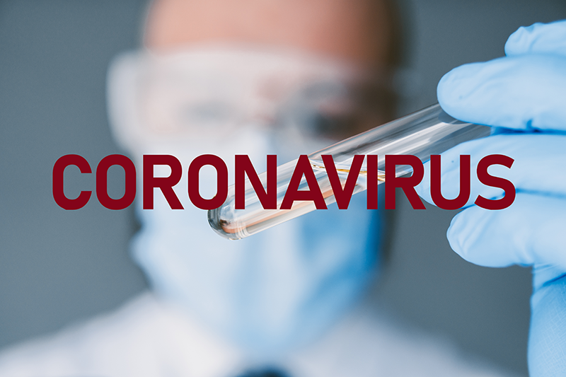 Doctor holding a vial with the word Coronovirus.