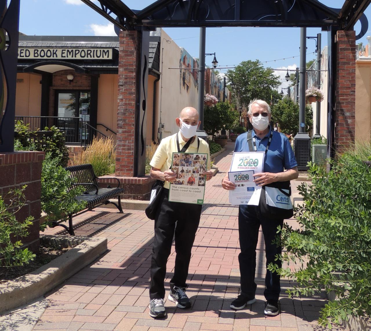 Two U.S. Census Workers stand next to each other with posters