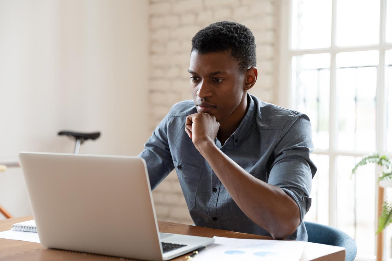 Serious man studying laptop
