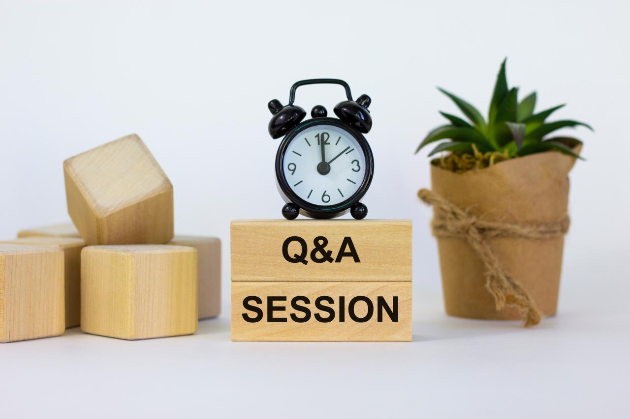 clock on top of wooden blocks with q and  a session written on them and other decoration next to it. 