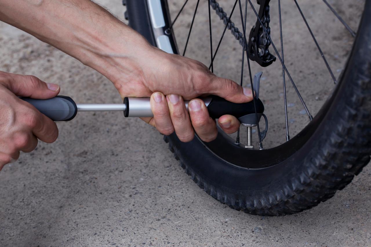 Hands inflating bicycle tire