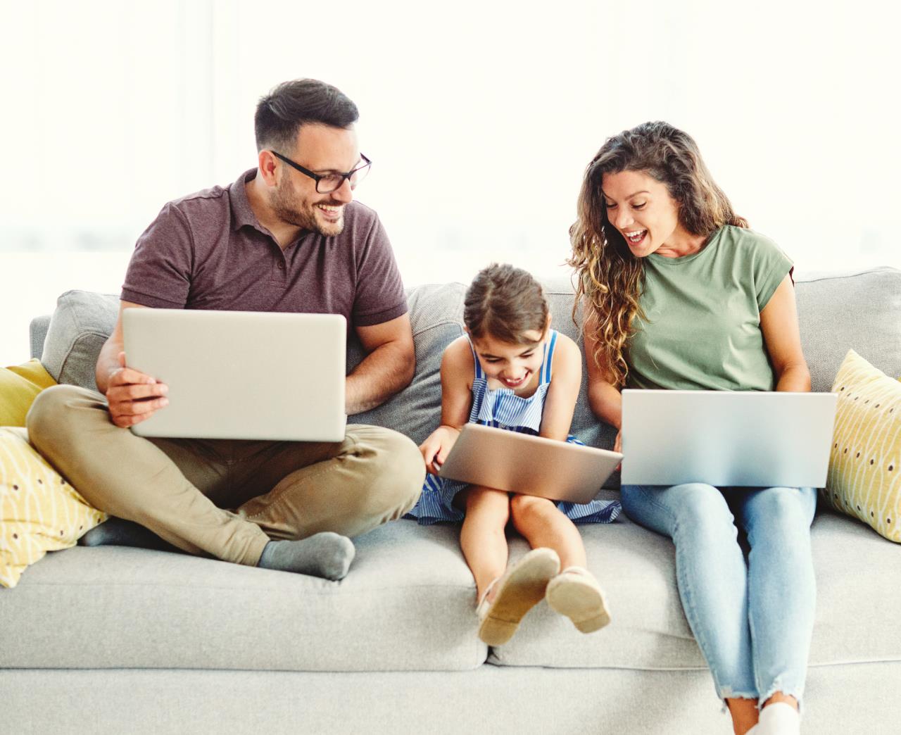 Happy family on couch with laptops