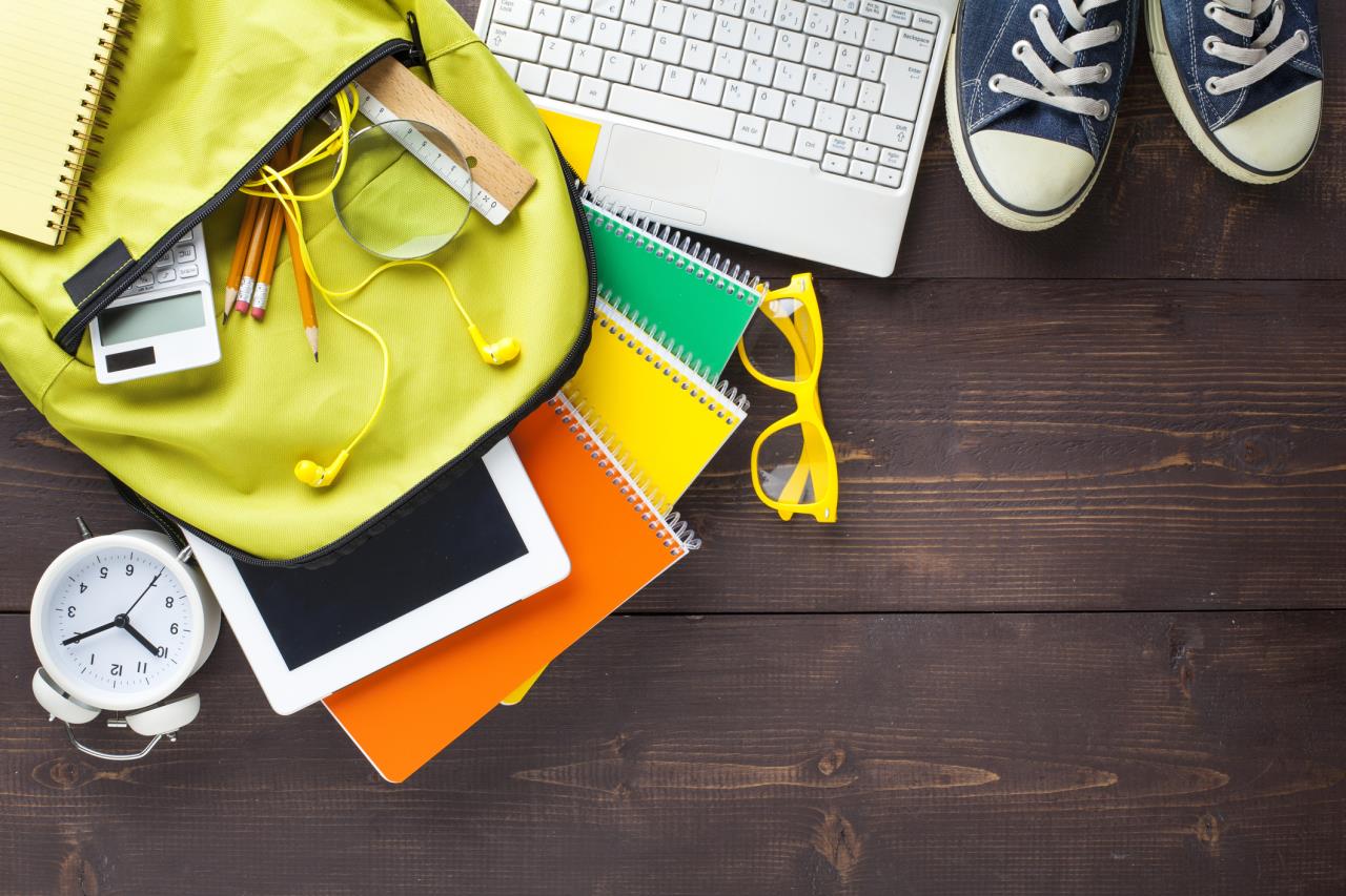 Array of school supplies on a wooden surface, including a computer keyboard