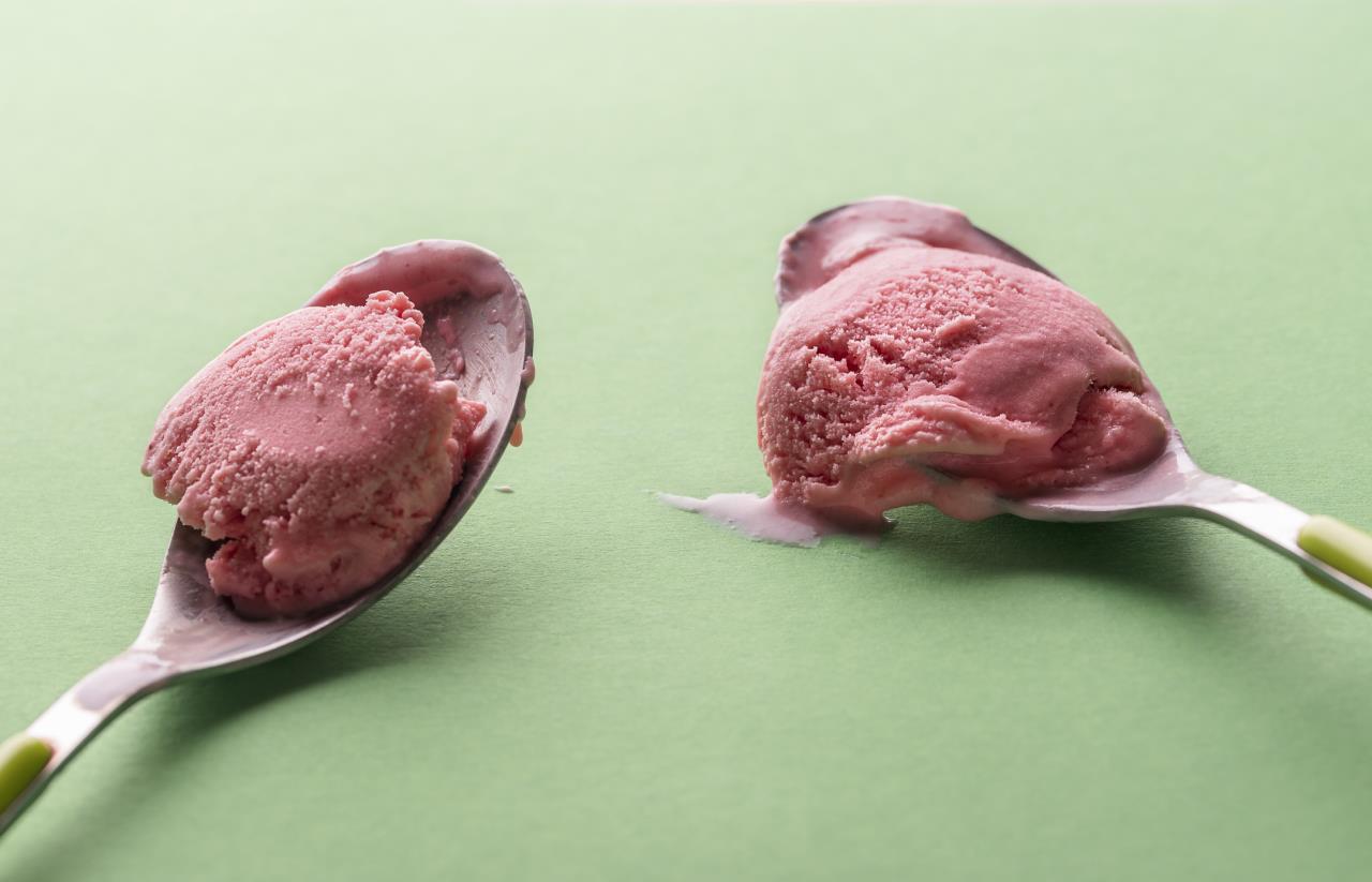 Two small spoons with strawberry ice cream