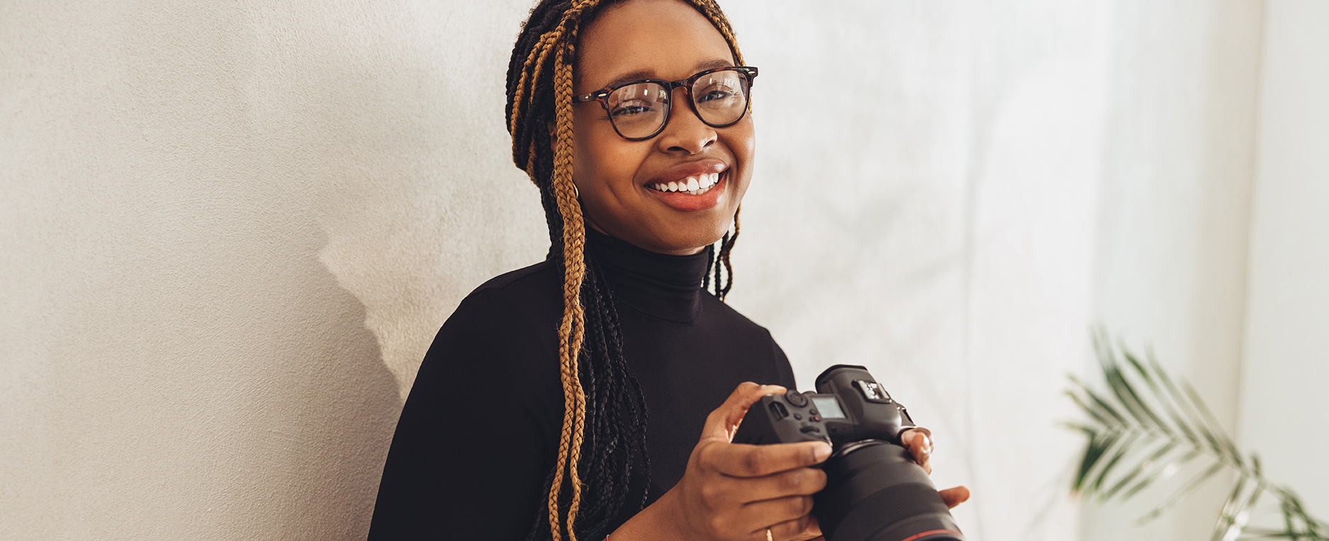 Happy young photographer smiling at the camera