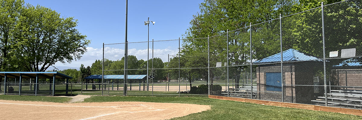 A ballfield and fencing are pictured against a blue sky at Clark Centennial Park.