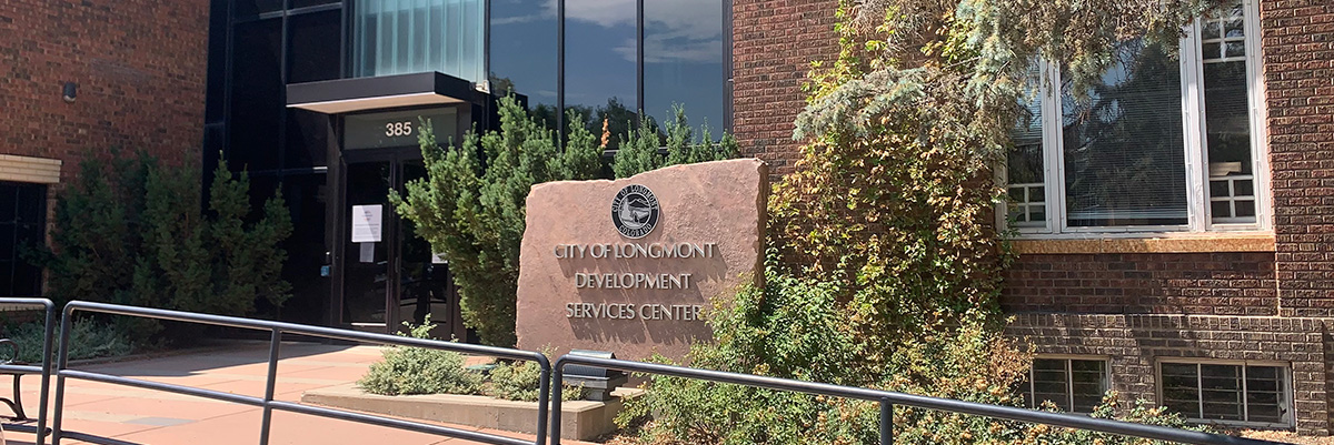 Photo shows the City of Longmont Development Services Center, a brick and glass building at 385 Kimbark Street.