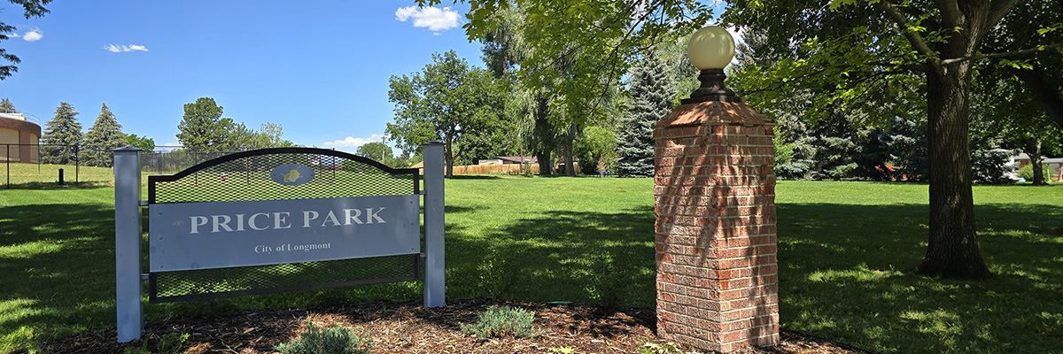A "Price Park" sign appears next to a lage tree set against a backdrop of green grass.