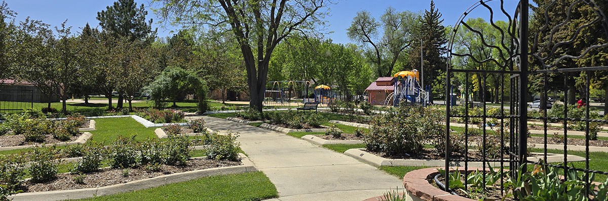 Gardens, play structures and parks buildings are seen in Longmont's Roosevelt Park.