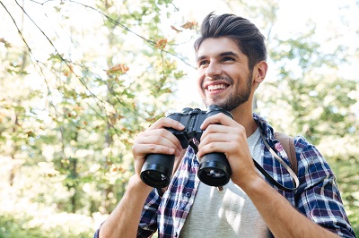 young man with binoculars bird watching