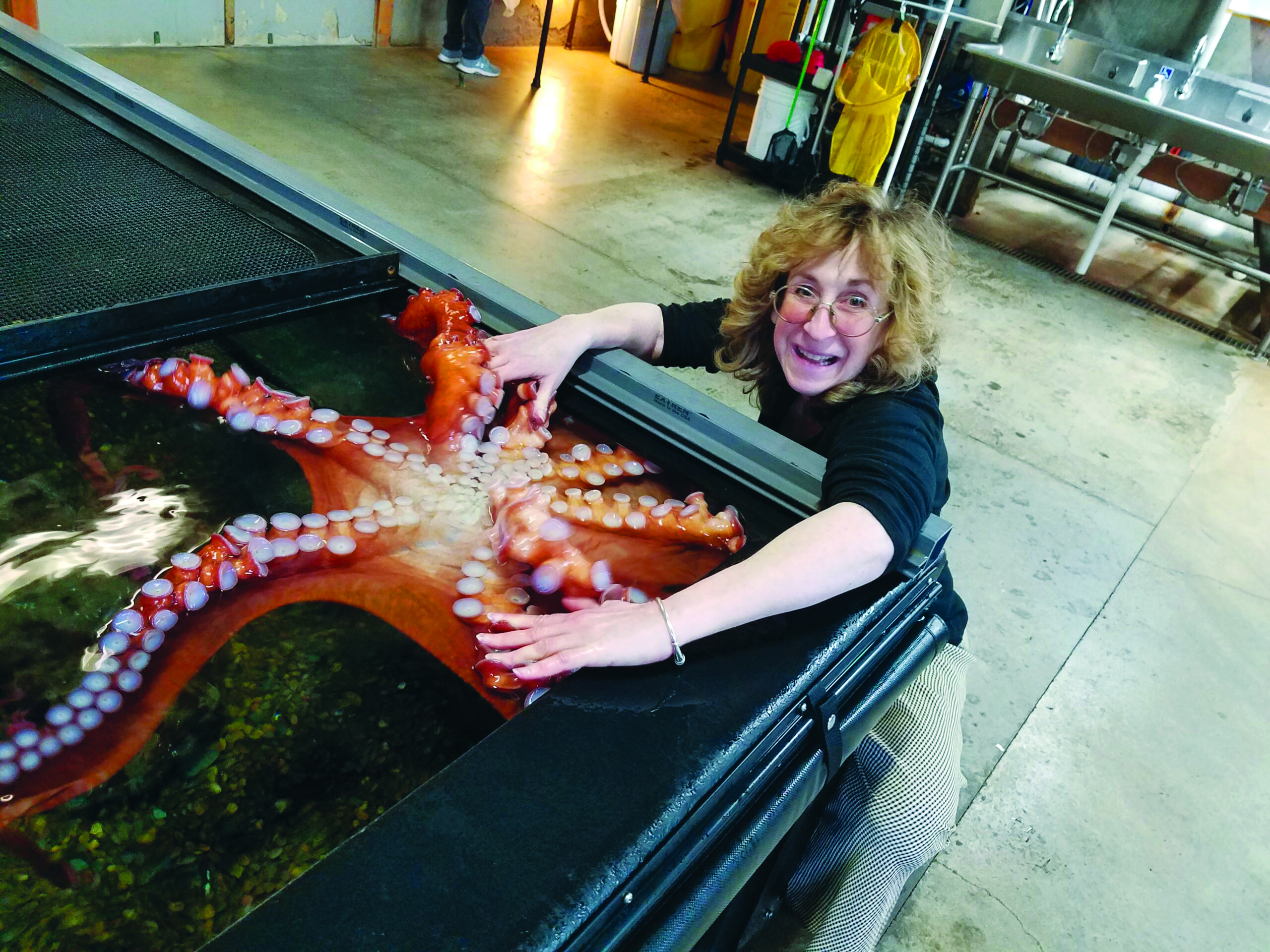 Author Sy Montgomery poses with an octopus at the Oregon Aquarium