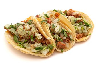 Three street tacos, with meat, onions and cilantro, appear on a white background.