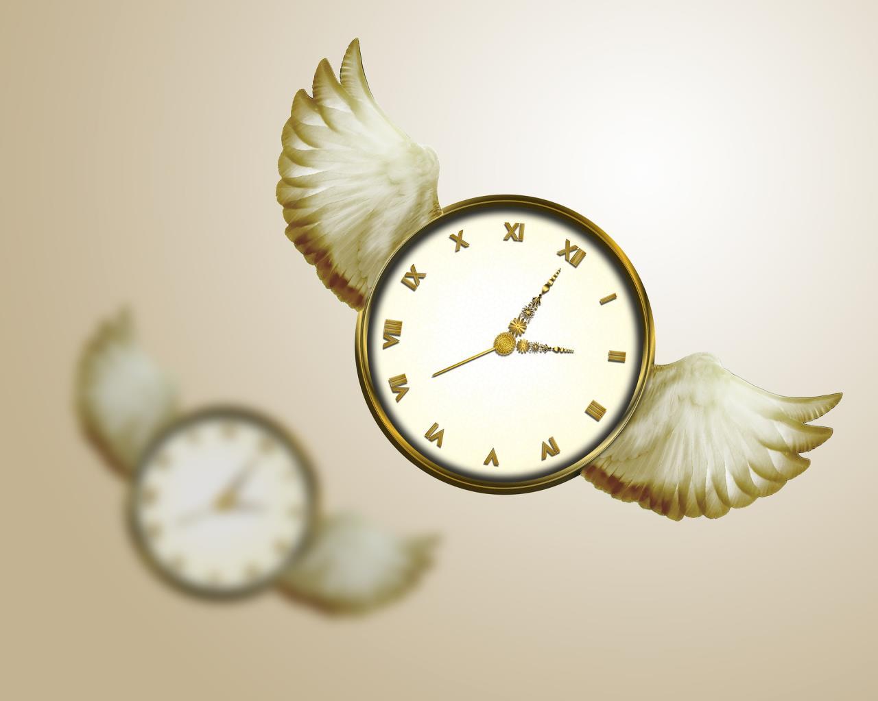 Image of clock with wings and its reflection