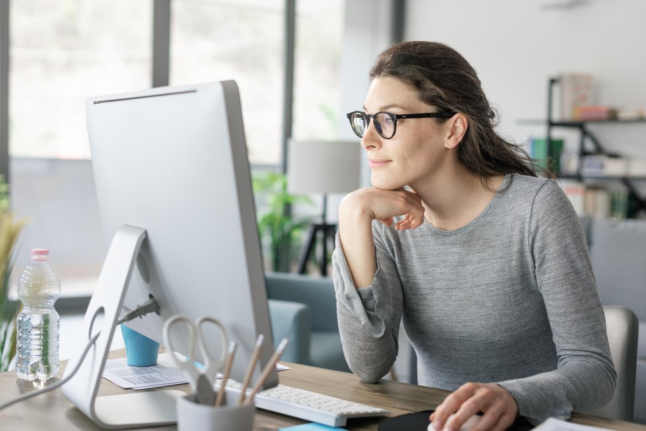 Woman in Glasses Working From Home at Desktop Computer