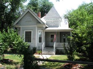 The H.P. Nelson house is a grey house with white trim in the Queen Anne Style