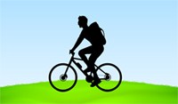 cyclist riding on green hill