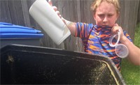 youngster putting compost into bin
