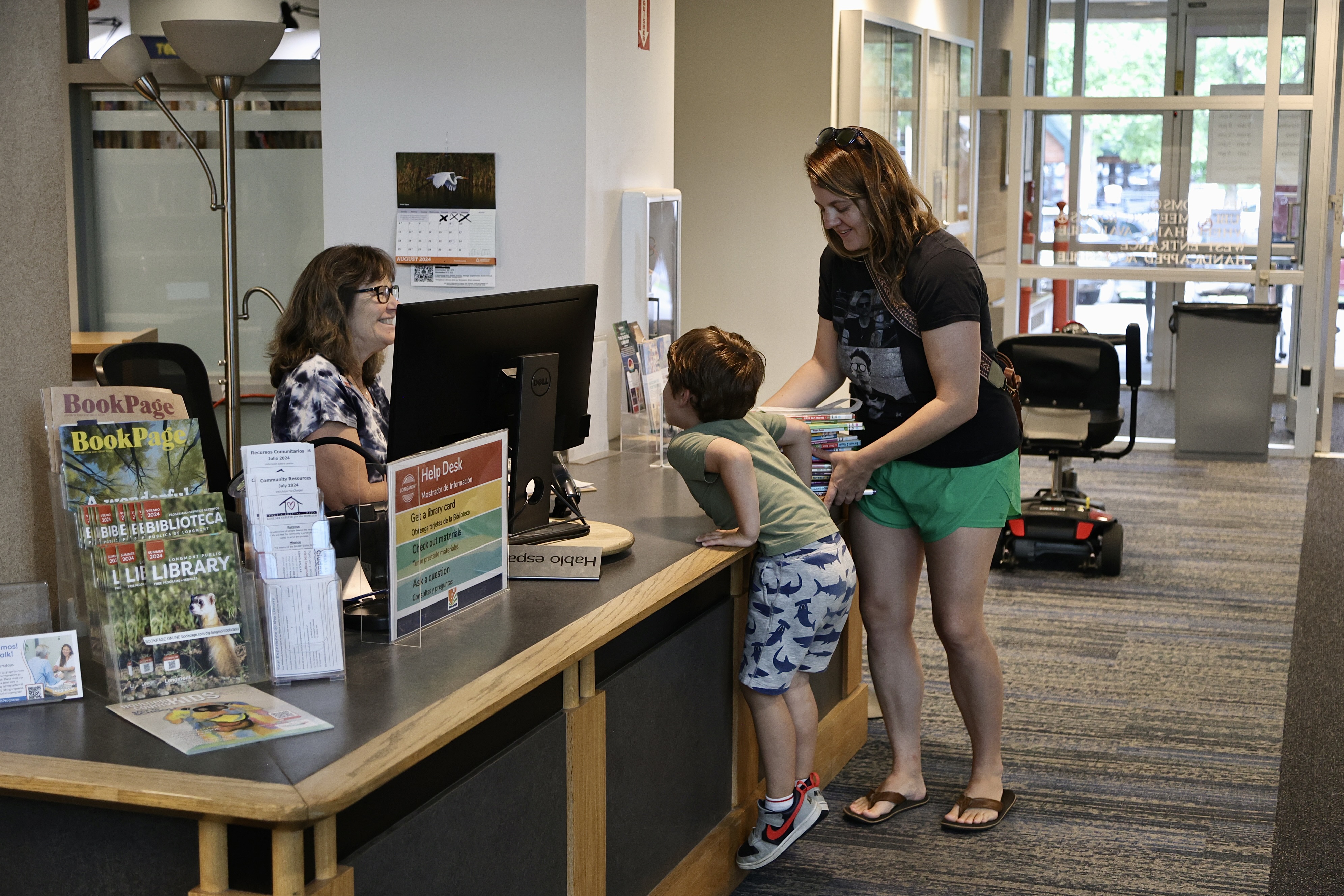 A mom and child check out books at the Longmont Library help desk