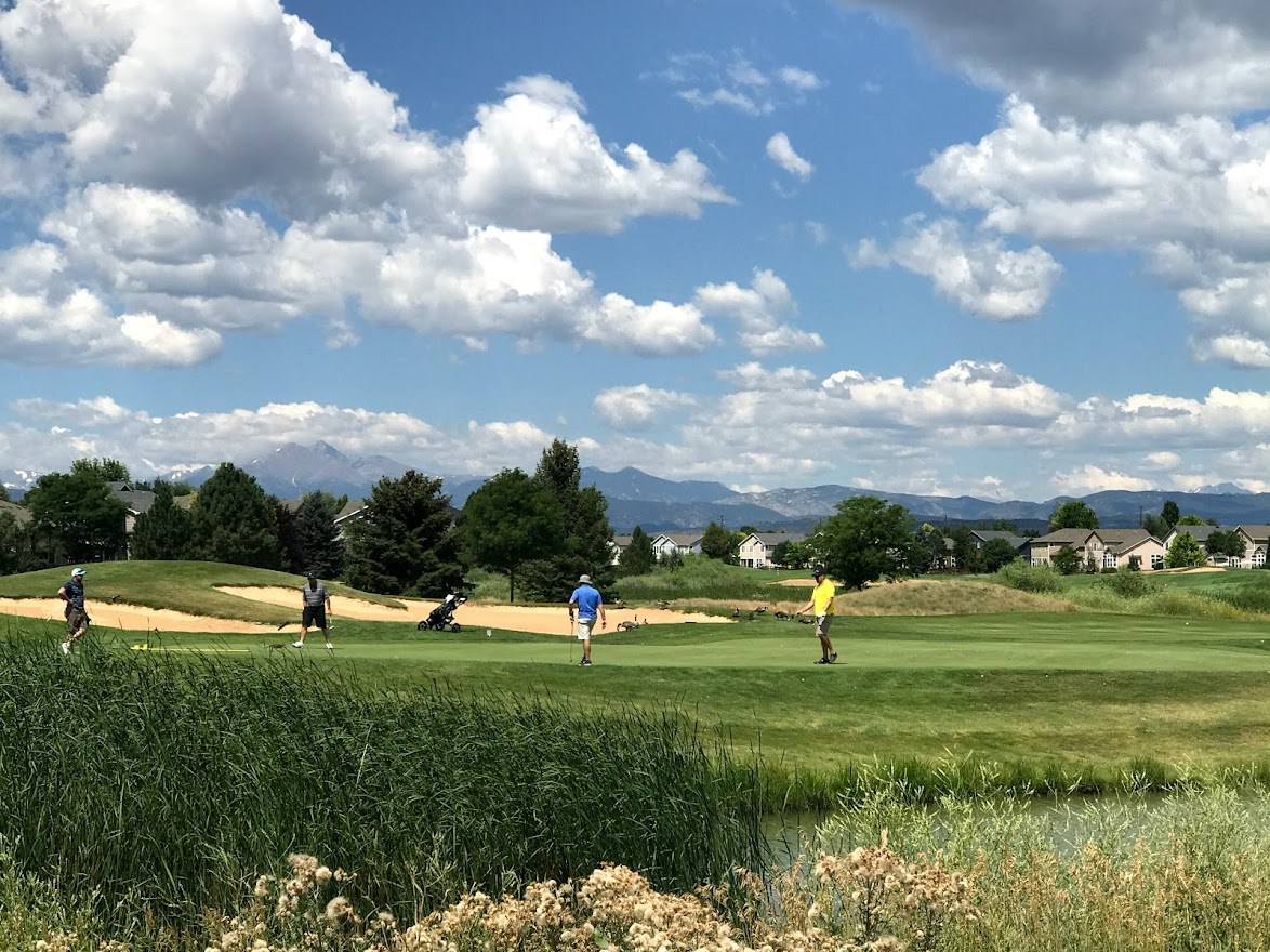 person playing golf at Ute Creek Golf Course in Longmont, CO with mountains in the background