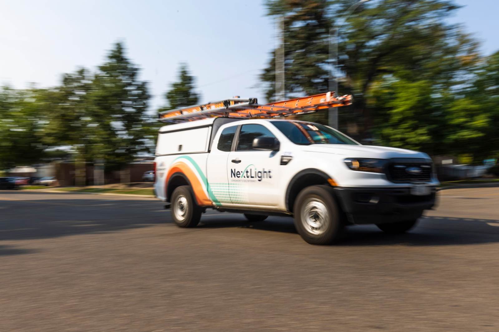 NextLight truck on street, driving toward right side of picture