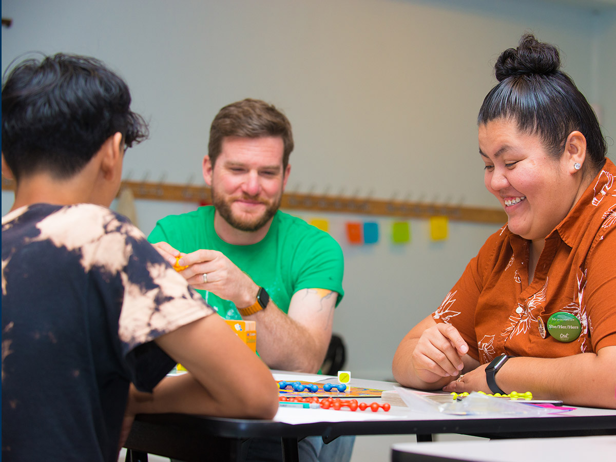 Students and staff enjoy a board game at the Longmont Youth Center.