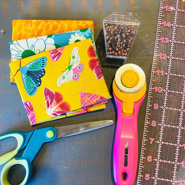 fabric, scissor, and a cloth cutter on a table