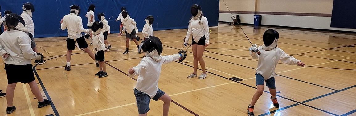 Youth with white fencing equipment practice with partners.