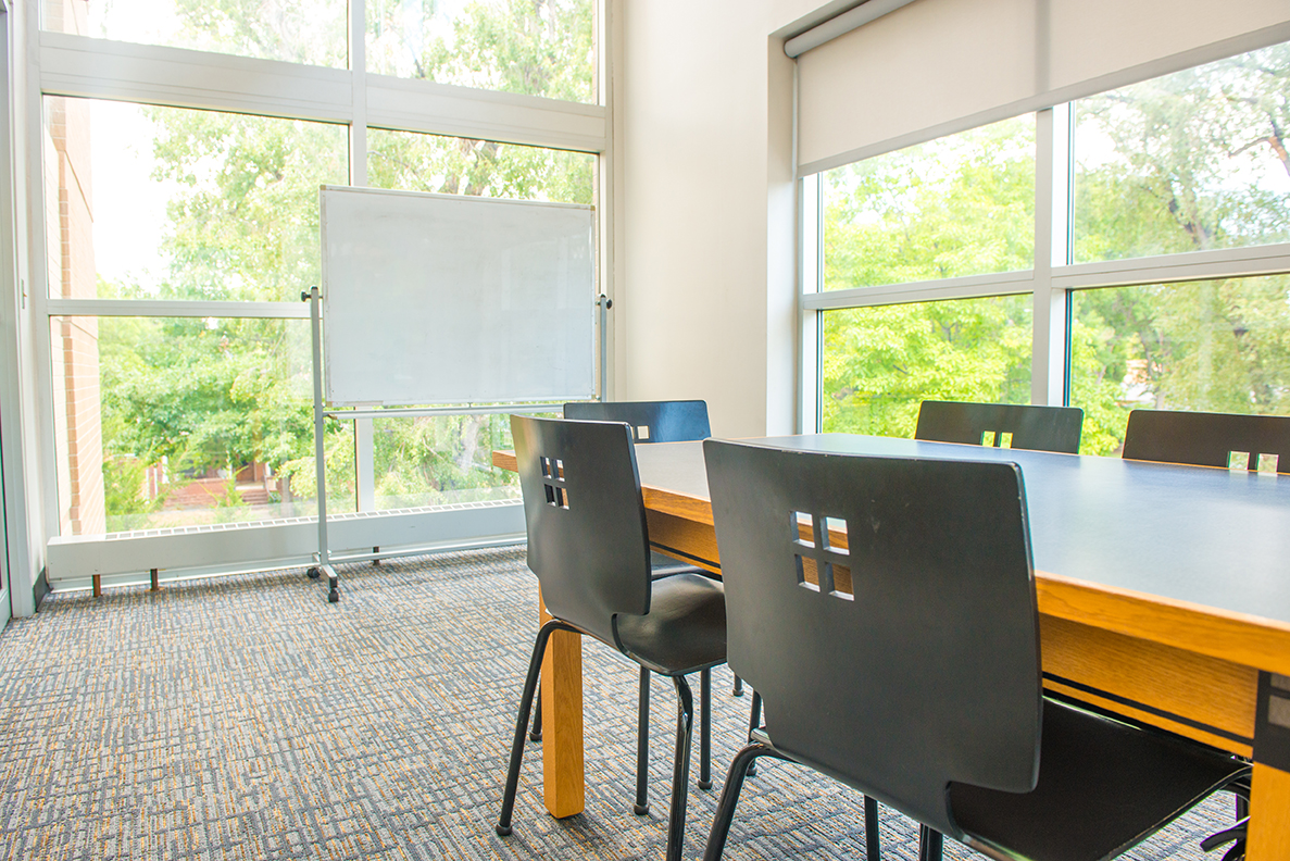 Table and chairs as well as a white board are included in a study room at the Library