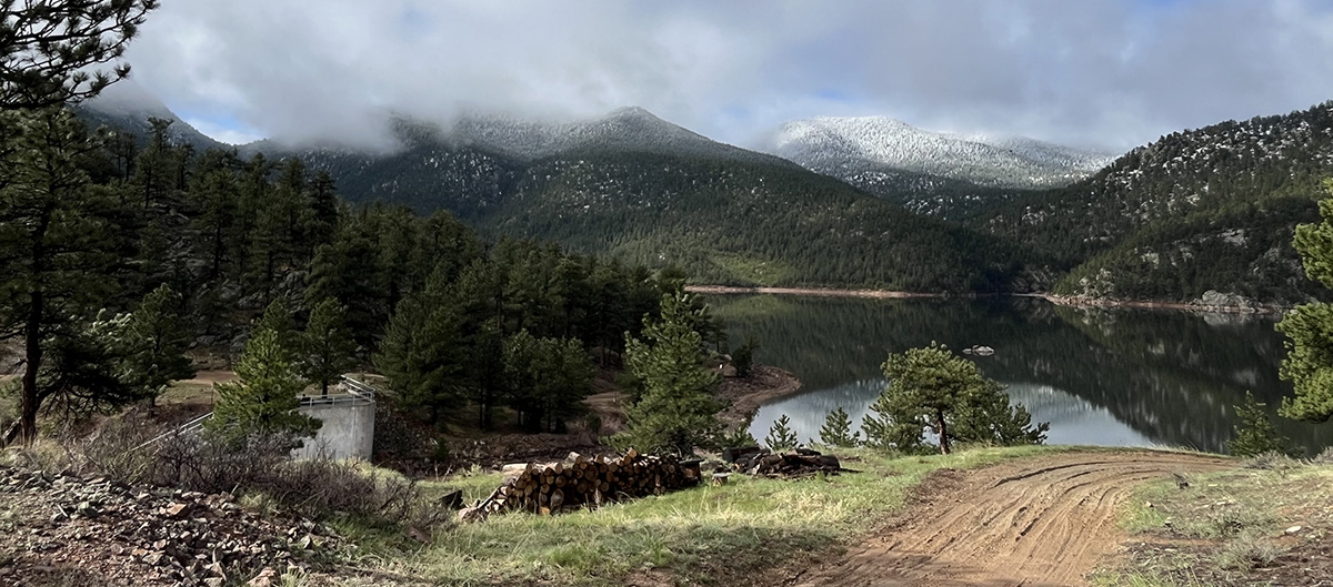 Photo shows the button rock area with green woods and a mist over the water.