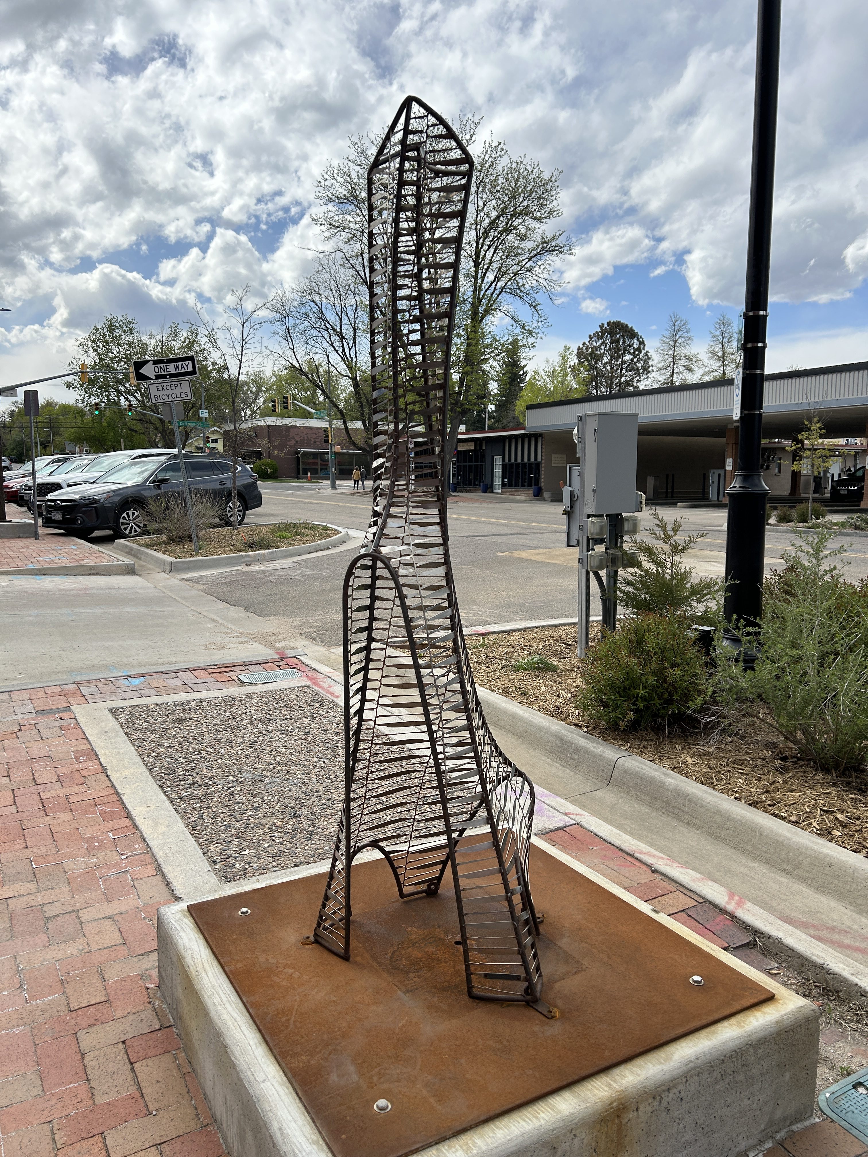 an abstract steel sculpture on the sidewalk