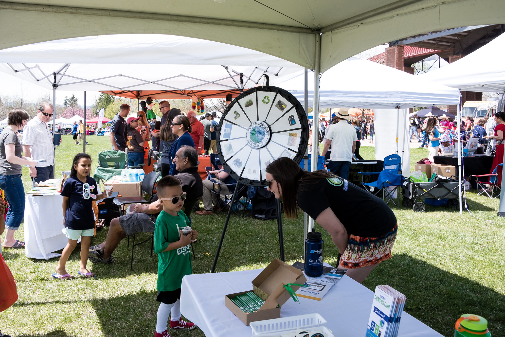 Community event showing various people with young boy interacting with City of Longmont Sustainability staff