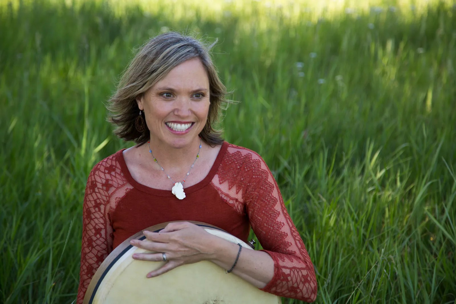 Woman in a grass field in a red shirt