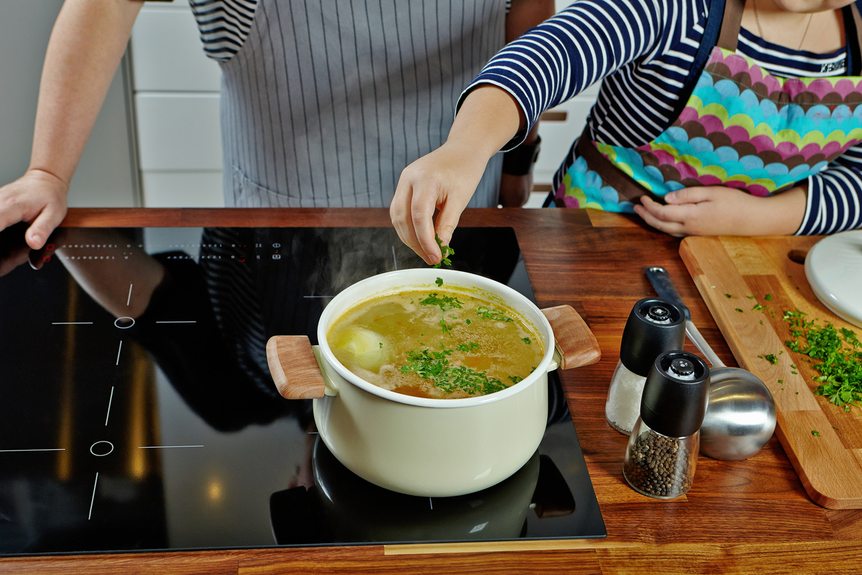 Woman and girl cooking on electric induction surface