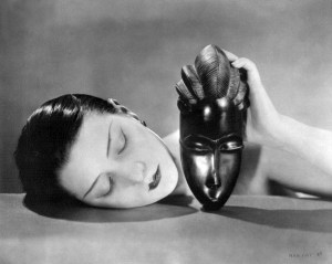 Black and white film still with a woman with dark hair and a seashell