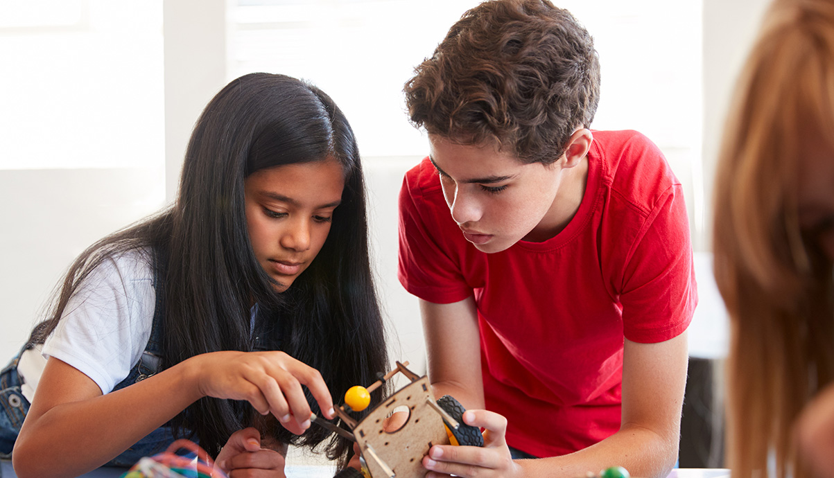 Two grade school aged students work on a craft project