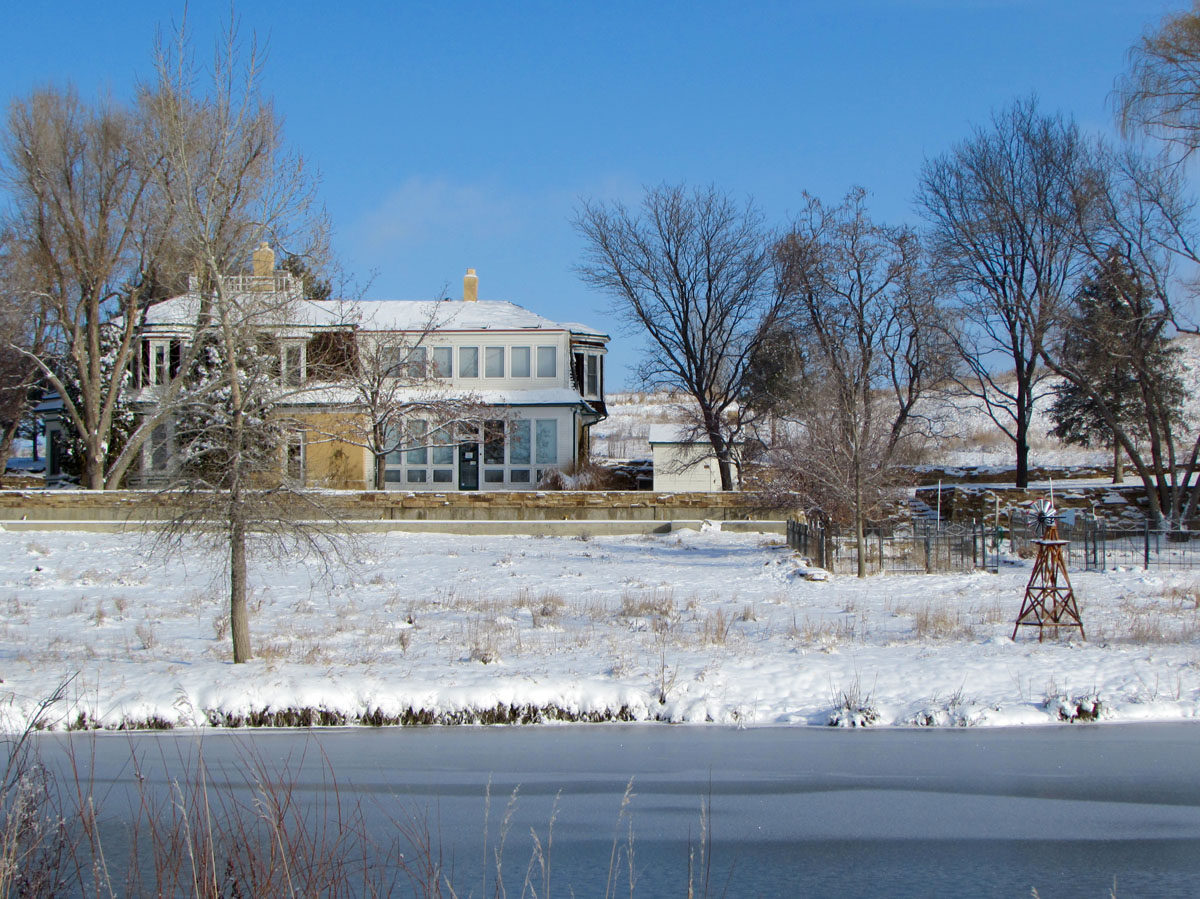 Sandstone Ranch House in Longmont CO behind frozen pond and snow