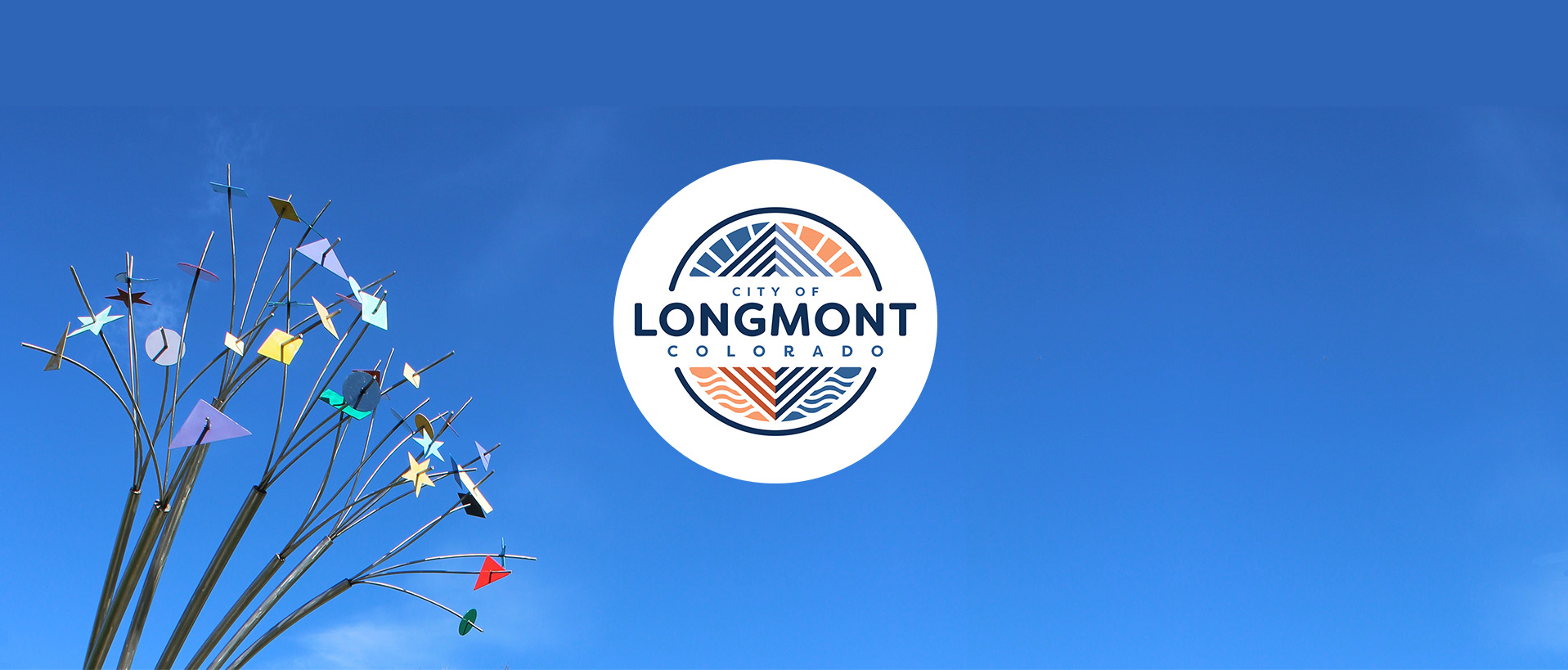 The sculpture "Hulu" is seen in the corner of a sky blue sky, with the City of Longmont logo placed in the middle of the photo.