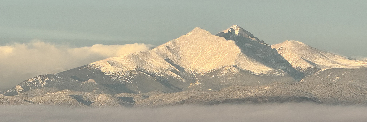 The Longs Peak mountain area is seen above the cloudline. above a