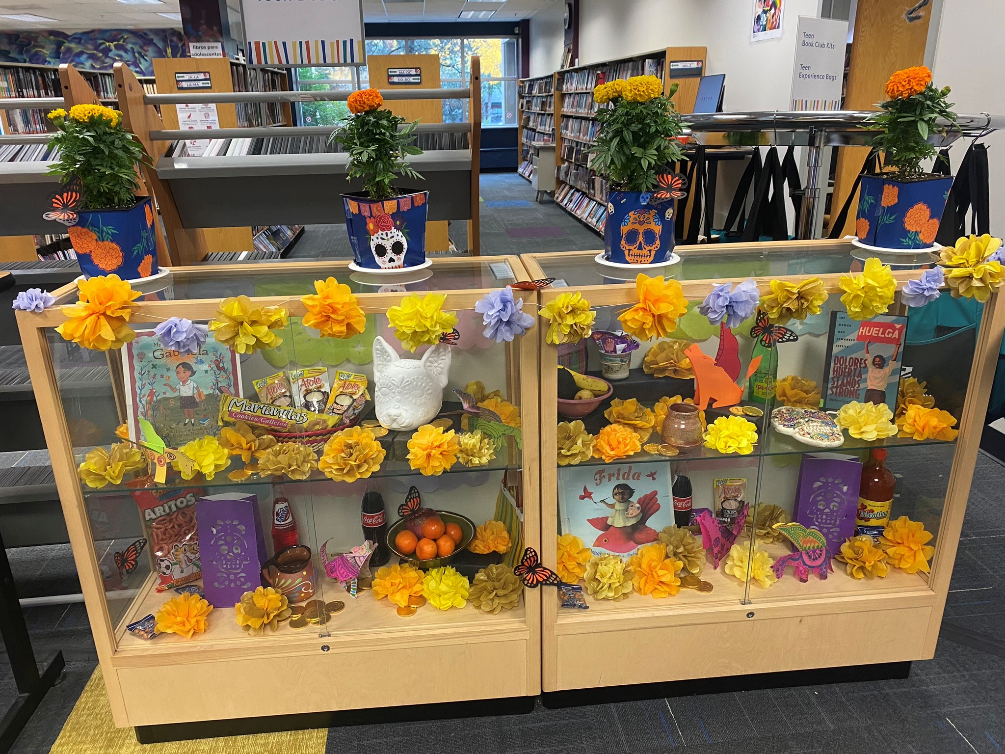A display of offerings for Day of the Dead in a glass case