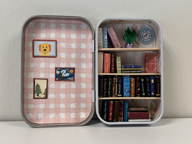 a opn tin decorated with miniature books and wallpaper