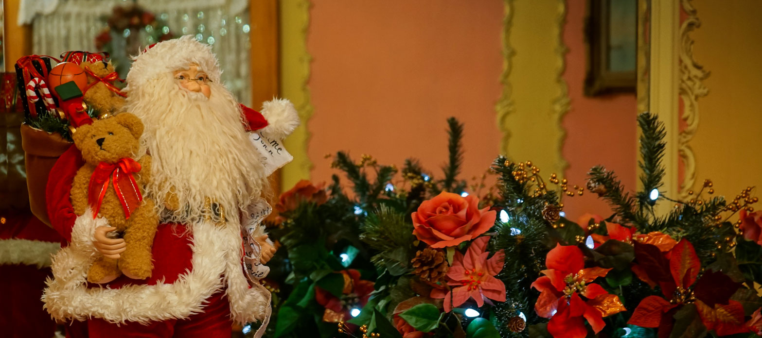 Santa and sleigh decoration next to red poinsettia flowers at Callahan House