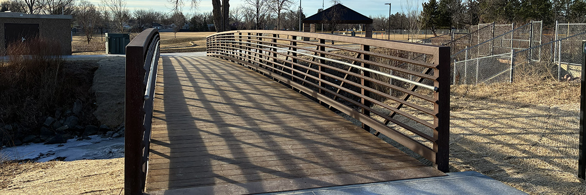 A newly refinished wood plank bridge is pictured at sunrise.