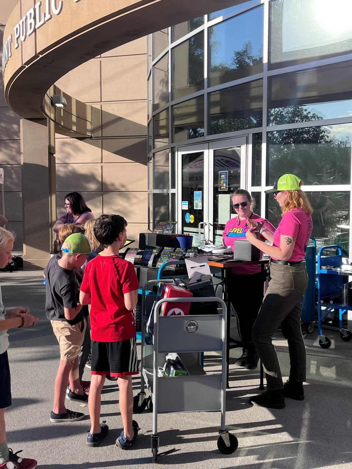 LevelUp Longmont volunteers help children arriving at LevelUp Longmont from a station outside the Longmont Library