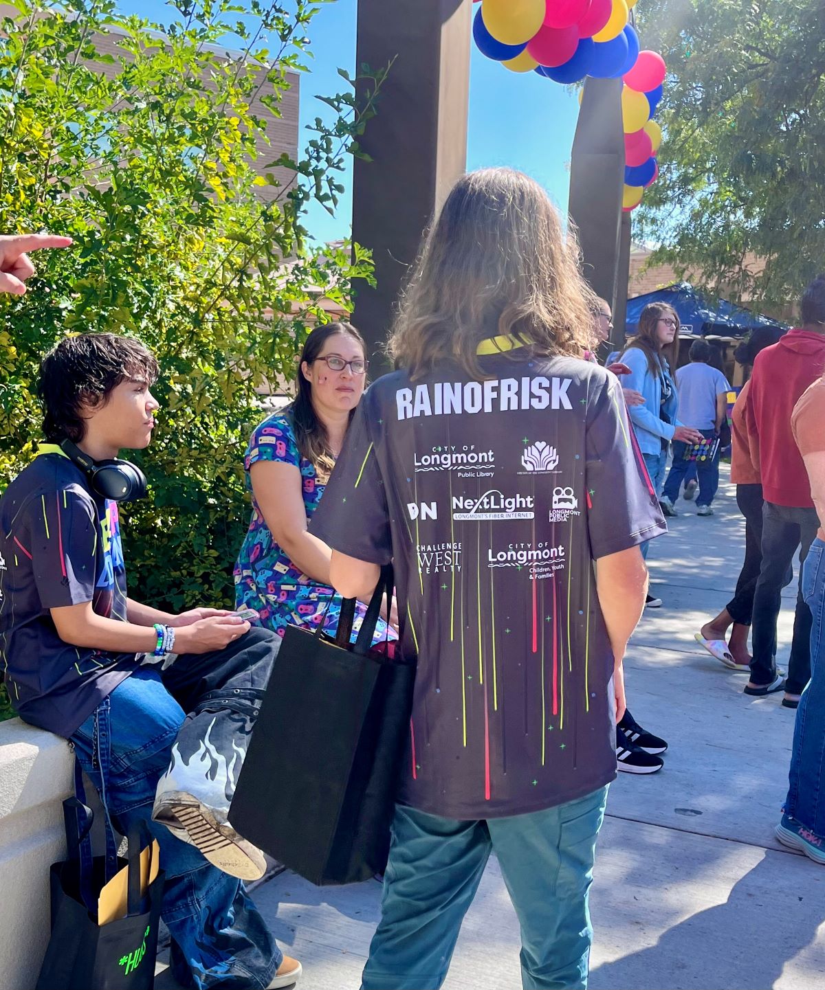 A LevelUp Longmont participant in an event T-shirt is visible from the back, with the sponsors showing on the back.