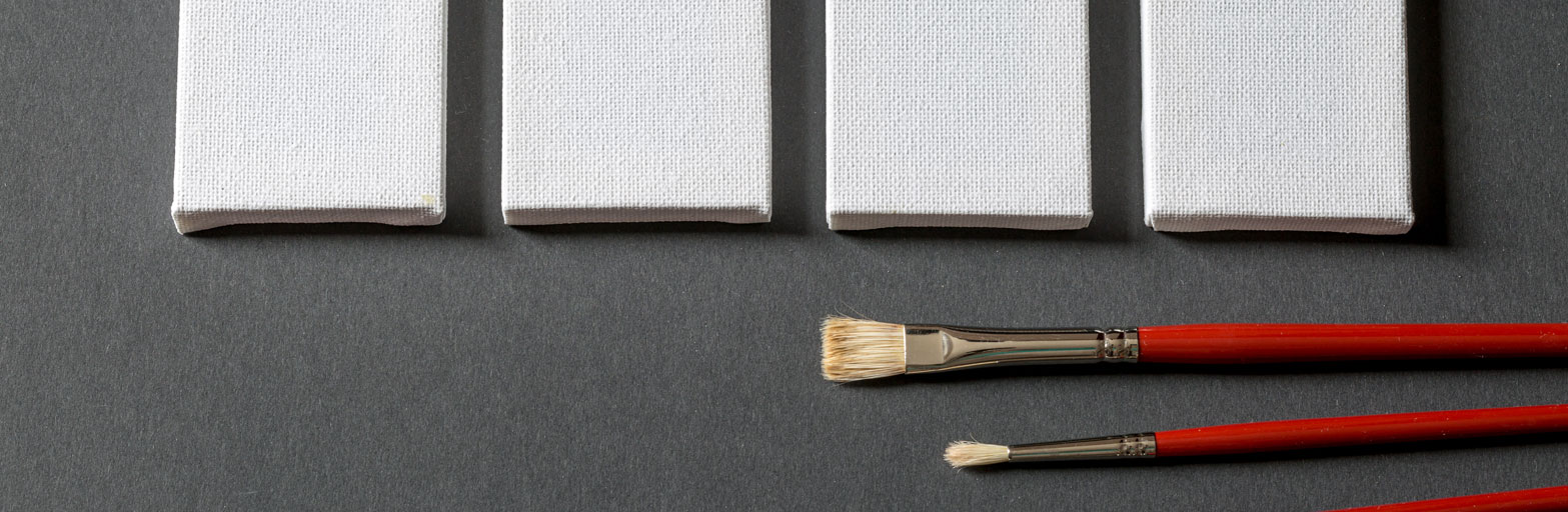 four small white canvases on a gray background with red paintbrushes