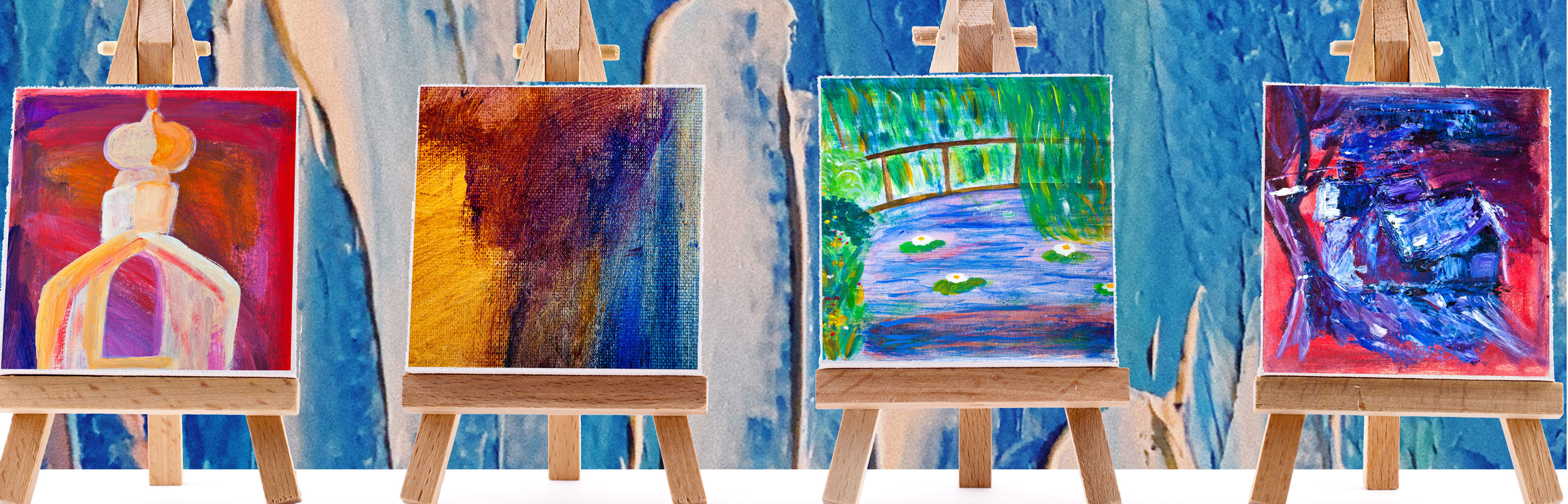 four tiny paintings of landscapes and color blocks on easels on a white background