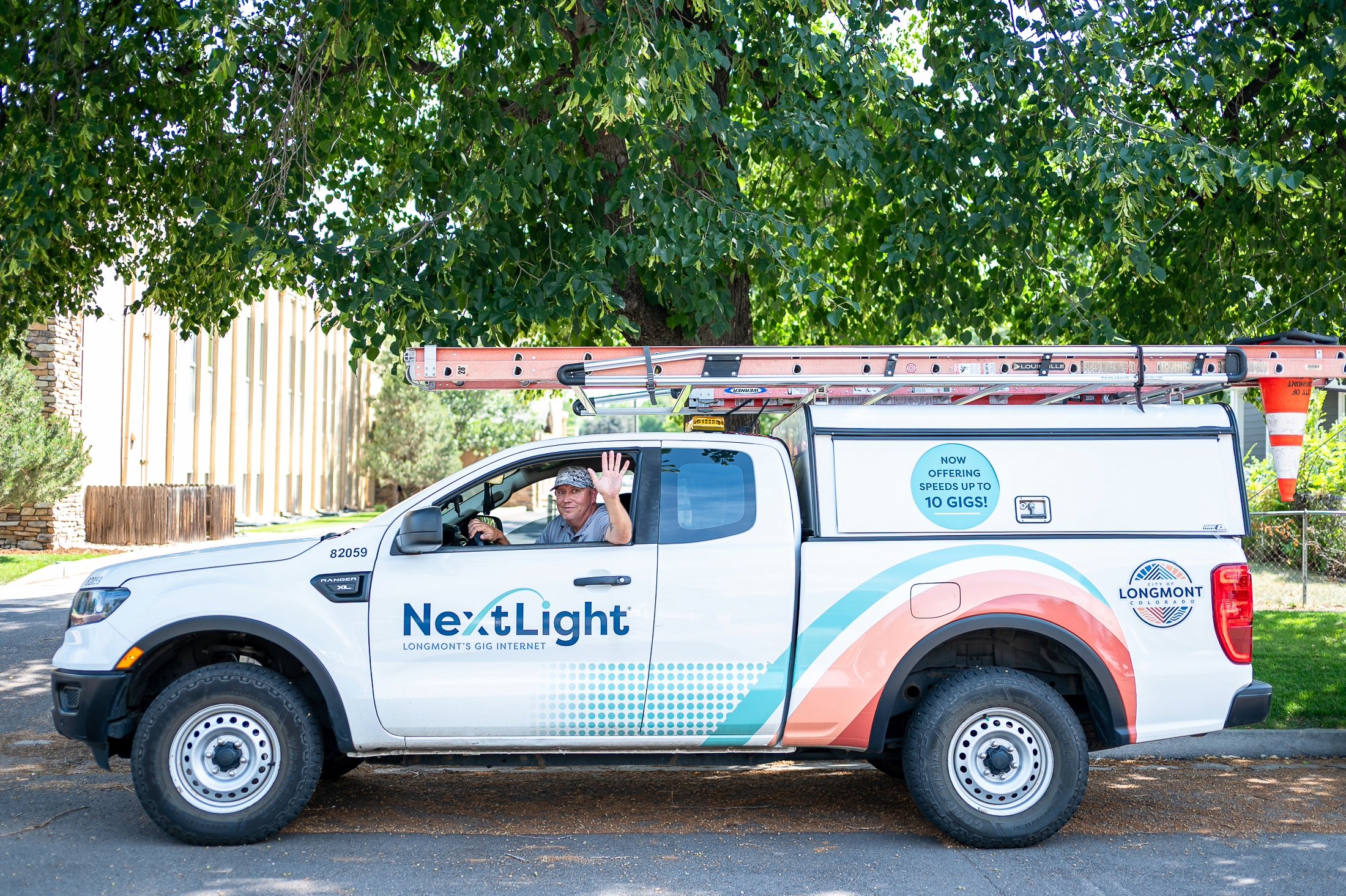 Image of a NextLight Technician waving in a NextLight branded truck.