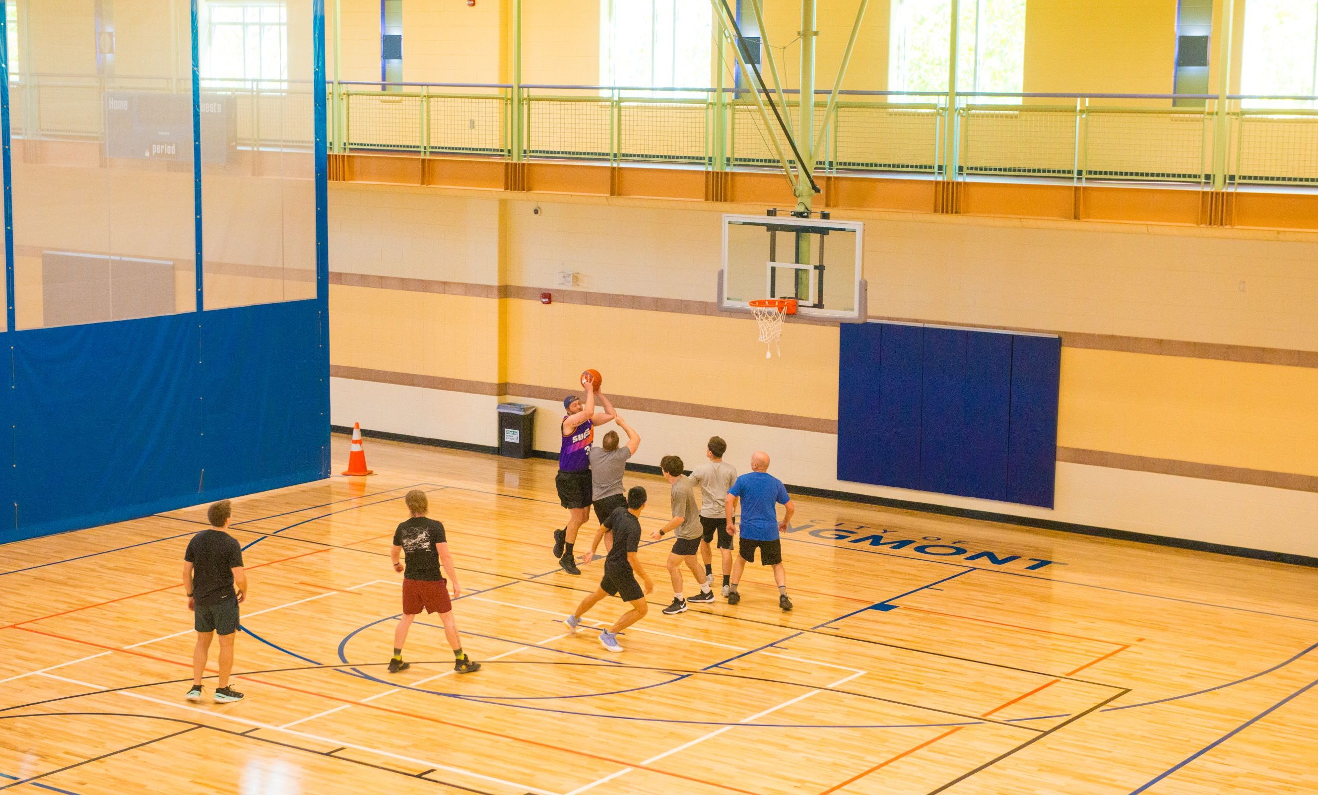 six men playing a pick-up game of basketball in the gym at the LRC